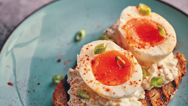 boiled-eggs-with-cottage-cheese-on-a-toasted-slice-of-brown-bread-picture-id1136590445
